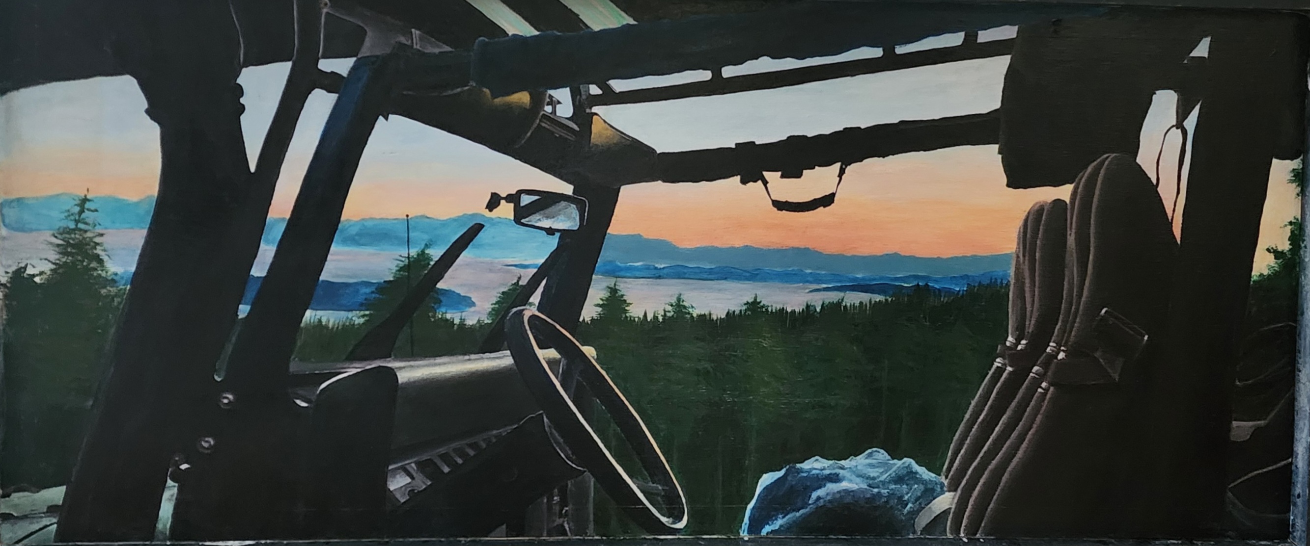 View from inside offroad vehicle overlooking forest, mountains and ocean at sunset